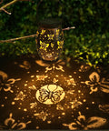 Butterfly Solar Powered Outdoor Metal Lanterns Set Of 2 Waterproof Hanging Patio Lights casting butterfly shadows in garden