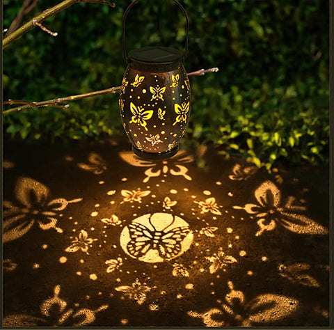 Butterfly Solar Powered Outdoor Metal Lanterns Set Of 2 Waterproof Hanging Patio Lights casting butterfly shadows in garden
