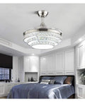 42 Inch Retractable Blade Ceiling Fan Featuring Glowing Crystal Chandelier And Smart Remote Controls For Tunable Led Lights In A Legit Bedroom Or Dope Living Room Vibe, installed in a modern bedroom.