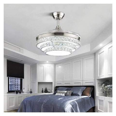 42 Inch Retractable Blade Ceiling Fan Featuring Glowing Crystal Chandelier And Smart Remote Controls For Tunable Led Lights In A Legit Bedroom Or Dope Living Room Vibe, installed in a modern bedroom.