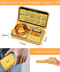Pocket Digital Gram Scale 300g Capacity With 0.01g Precision sleek gold case with skull motif, displayed open and in hand.