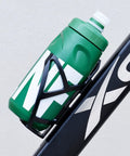 Green Leak Resistant Squeeze Lid Water Bottle for Biking and Hiking on bike frame, ergonomic grooves, detachable cap visible