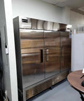 Rock Solid 82 Inch Wide Commercial Reach In Freezer With Three Doors And 72 Cubic Feet Capacity Stainless Steel in a kitchen setting.
