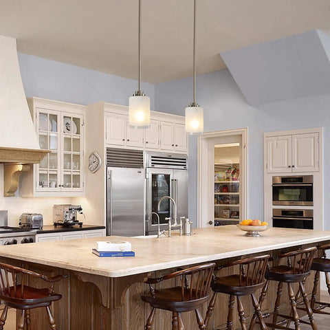 Two Pack Brushed Nickel Pendant Lights With White Linen Glass Shades illuminating a kitchen island with wooden chairs and stainless steel appliances
