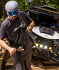 Front view of a UTV with a 4500 lb SuperATV Black Ops winch kit installed in mud.