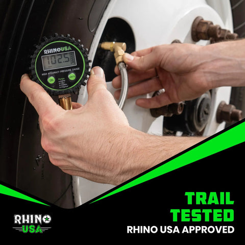 Front view of Rhino USA digital tire pressure gauge with glow dial and braided hose attached to a tire valve.