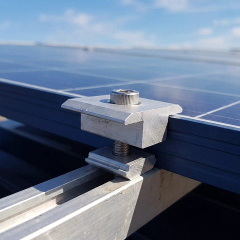 Close-up of Premium Aluminum Solar Panel Mid Clamp Bracket For Roof Mount No Drill Setup, securing glass panel edge.