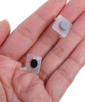 Two silicone push button switches in a hand, part of the 40 Piece Silicone Push Button Switch Replacement Keypad Membrane.