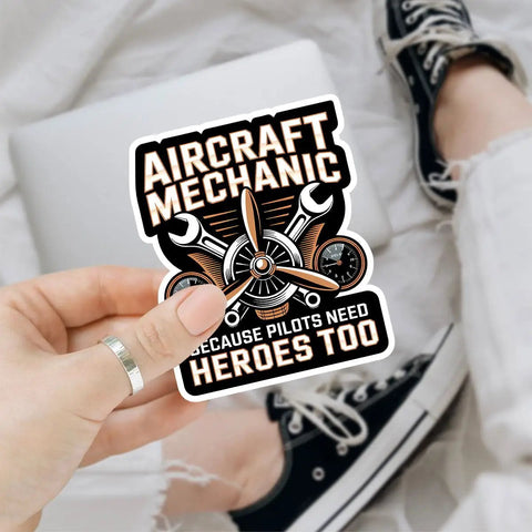 Plane Techs And Pilots Sticker Pack: We Fix What Your Pilot Breaks Funny Aviation Maintenance Decals held in hand over laptop.