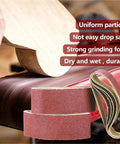 Five Piece Pack Of Top Shelf 915X100Mm Sanding Belts For Belt Sanders With Tough As Nails Abrasive Paper For Woodworking And Metal Jobs Delivering A Sweet Finish And Killer Grinding Power, showing sanding belts with wood.