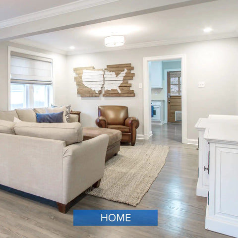 Modern living room with beige sofas, wooden armchair, and wall art. Lit 6500 Lumen A21 LED Bulb Replaces 450W Incandescents, 5000K Daylight, 35W, E26 Non Dimmable, 25,000 Hour Lifetime, Flicker Free, Energy Efficient Home Office And Workshop Lighting.