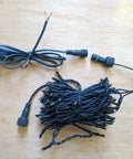 33Ft 100 LED Outdoor Waterproof String Lights Warm White For 12V Low Voltage Landscape Lighting coiled on a wooden surface