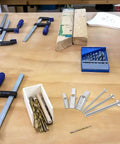 Workbench with assorted tools and 24 Piece Toggle Bolt Kit For Drywall With Wing Nuts And Boxed Set on display