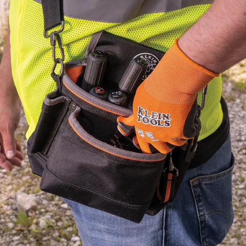 Person wearing Rugged Knit Dipped Work Gloves with Nitrile Coating for Cut Resistance ANSI A1, holding tools in pouch.