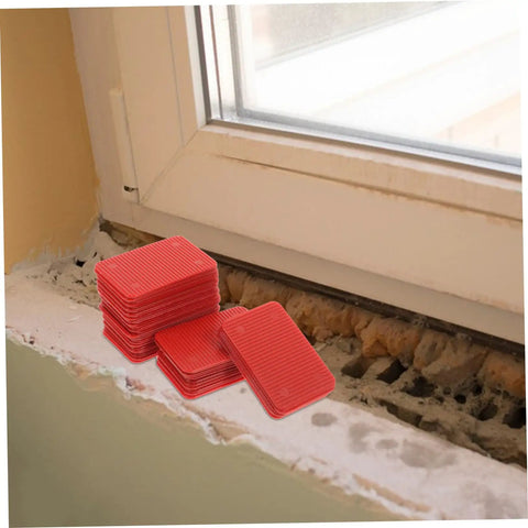 100 Pcs Plastic Door Frame Shims For Windows And Doors, Load Bearing Leveling Wedges, red shims near a window frame