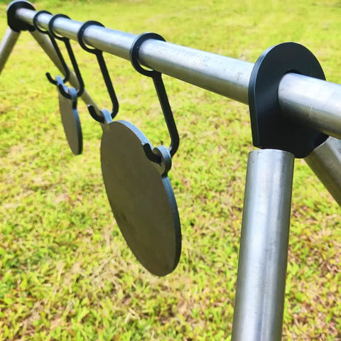 AR500 Steel Gong Target 3 Eighths Inch Thick For Precision Shooting hanging from metal stand on grass