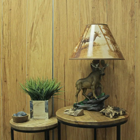 Wildlife Moose Table Lamp With A 12 Inch Forest Print Lampshade For Living Rooms Cabins And Bedrooms Delivers Cozy Warm Glow And Striking Rustic Decor Standing 20 Inches Tall For A Commanding Home Accent on wooden table with plant and decor