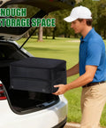 Man placing Golf Trunk Organizer With Two Layer Storage And Separate Compartment For Two Pairs Of Shoes in car trunk, grass background