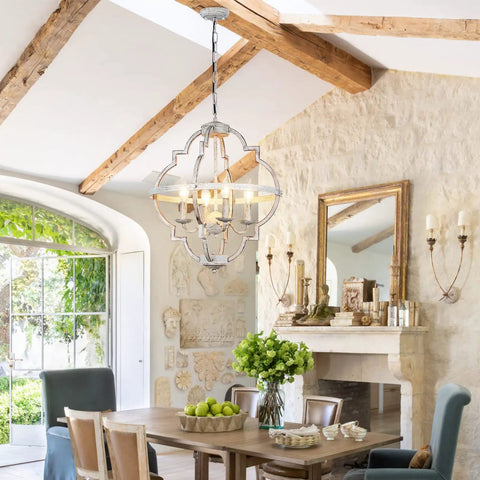 4 Light Farmhouse Candle Chandelier With Dope Open Orb Frame In Rustic White Finish hanging in a cozy dining room.