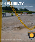 2 Inch By 100 Foot Yellow Plastic Safety Chain With SunShield UV Resistant Technology outdoors on construction site.