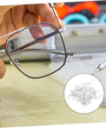Hand holding rimless eyeglasses with 200 pcs eyewear rimless glasses washers cushions gaskets for quick repairs shown in close-up.