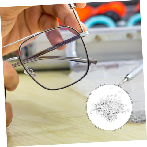 Hand holding rimless eyeglasses with 200 pcs eyewear rimless glasses washers cushions gaskets for quick repairs shown in close-up.