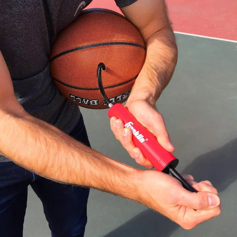 Man using All Sport Ball Maintenance Kit With 7.5 Inch Hand Pump And 3 Inflation Needles For Basketballs, Soccer Balls, Footballs, Volleyballs And More No Fuss Quick Inflation For Everyday Play on basketball