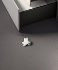 White Ceramic Star Cabinet Knob Small Decorative Drawer Pull Handle next to a cabinet on a dark floor