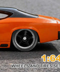 Close-up of an orange diecast model car featuring 1/64 scale wheels and tires set with real riders rims, 5 spoke silver and black.