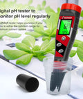 Hydroponics 4 In 1 pH Meter EC TDS Temperature Tester for Home Growers measuring solution in cup next to plants