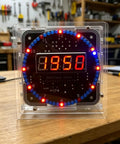60s Clock DIY Kit for Soldering Practice, digital clock with transparent case showing time, on a workbench