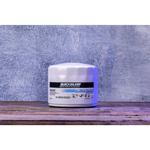 White spin-on oil filter for MerCruiser and GM Marine engines featuring MPleated media and anti-drain back valve on wood surface.