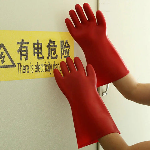 Hands wearing Heavy Duty Electrical Insulated Gloves Class 00 12KV 1.8mm Thick Rubber touching a warning sign.