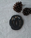Samurai Sword Koshirae With Tsuba Alloy 081-099 Black Finish Two Girl Motif Tsuba alongside pine cones