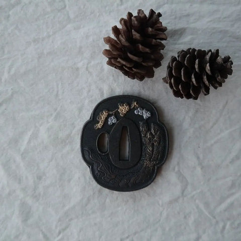Samurai Sword Koshirae With Tsuba Alloy 081-099 Black Finish Two Girl Motif Tsuba alongside pine cones