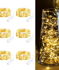 Six Pack Battery Operated Fairy Lights With Seven Foot Copper Wire 20 LED Waterproof String Lights For DIY Crafts Wedding Decor Table Centerpieces Mason Jars Party Ambiance with coiled lights and a vase display.