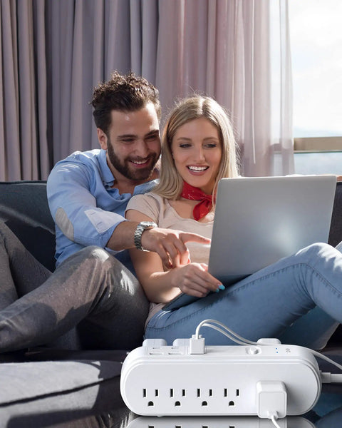 Couple using laptop with All In One Power Strip Surge Protector With USB C PD, 10 wide outlets, 6ft cord, on couch
