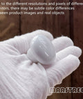 White Ceramic Round Kitchen Cabinet Knobs 10 Pack With Long And Short Screws displayed in a gloved hand