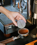 Premium 58mm Bottomless Portafilter With Thick Walnut Handle For Breville Dual Boiler And Oracle Touch Espresso Machines in use with coffee grounds.