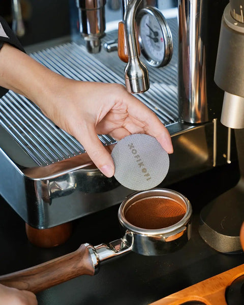 Premium 58mm Bottomless Portafilter With Thick Walnut Handle For Breville Dual Boiler And Oracle Touch Espresso Machines in use with coffee grounds.
