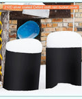 Built Tough 55 Gallon Drum Cover For Outdoor Water Storage Barrel With Grip Tight Drawstring Closure All Season Rain Snow Guard UV Protected covering two black barrels with snow.