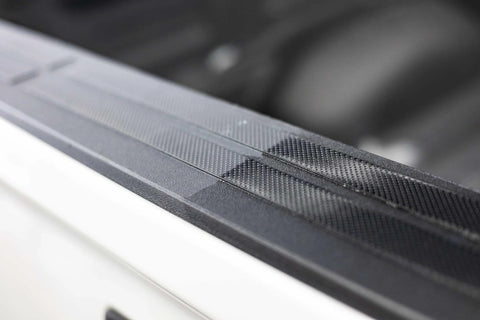 Automotive exterior door-sill trim in black textured plastic, close-up view along car body.