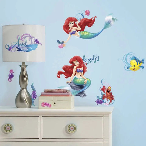 Disney The Little Mermaid Peel And Stick Wall Decals 6 Piece Vinyl Set on wall near white dresser and Ariel-themed lamp.