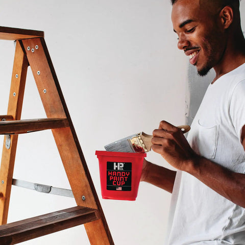 Person using Grab And Go 16 Oz Paint Cup With Magnetic Brush Holder For Trim Work and Touch Ups, ladder in background