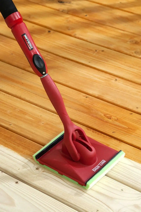 Deck Stain Pad With Groove Tool For Even Coverage On Flat Surfaces And Between Boards shown with wooden deck and threaded handle