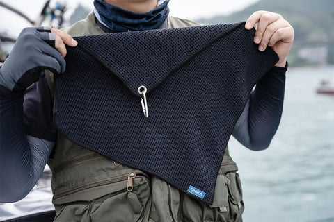 Man holding Grab And Go Clip On Microfiber Fishing Towels With Waffle Pattern, Quick Dry 16x16 Inch Towels in black, with carabiner.