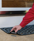 Person lifting doormat with Industrial Strength Outdoor Hook And Loop Fasteners for Extreme Weather on concrete surface