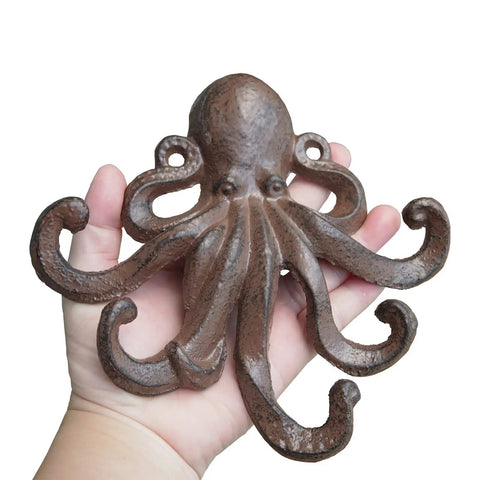 Heavy Duty Cast Iron Octopus Wall Hooks With Sleek Nautical Vibes And Aged Dark Brown Finish for hanging, in hand for size reference.