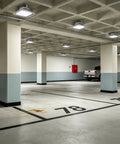 Heavy Duty 185W LED Explosion Proof Flood Light UL844 rated illuminating a spacious industrial parking garage.