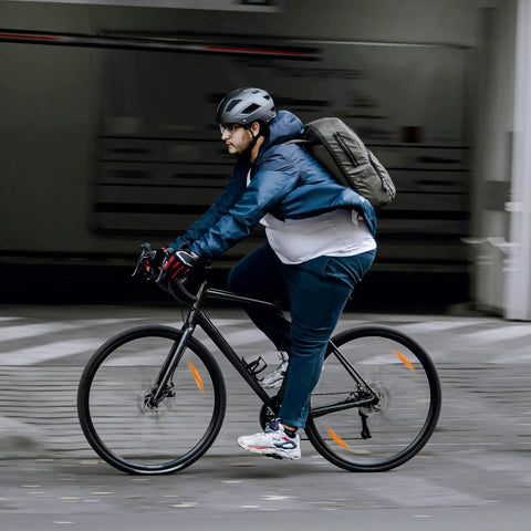 Cyclist riding a bike on the street, equipped with Beefed Up Heavy Duty 700C Bike Inner Tubes Set Two Pack Fits 700x25C Through 700x34C